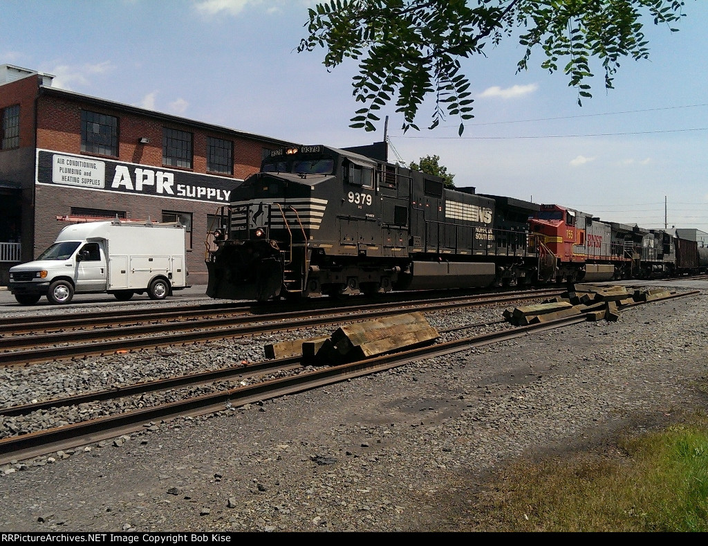 An oil train with a "warbonnet" in the lash-up passes Lebanon Plumbing Supply